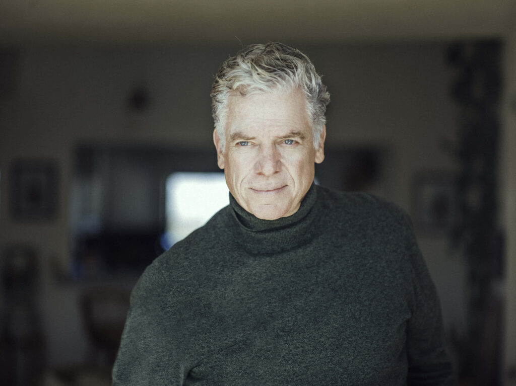 Christopher McDonald in dark turtleneck with calm expression soft light and blurred background wallpaper