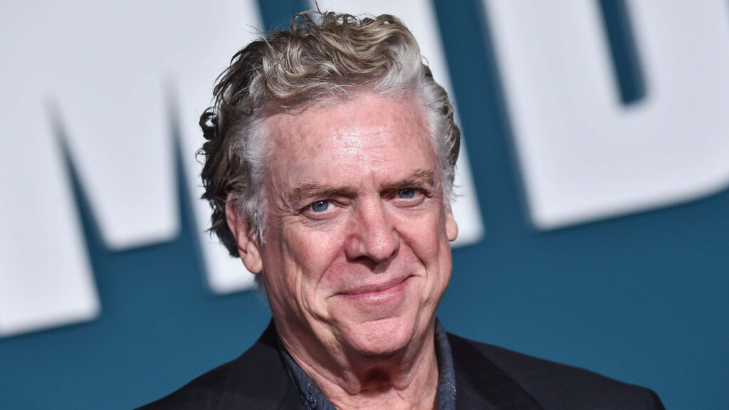 Christopher McDonald portrait with curly hair smiling sharp focus deep blue background wallpaper