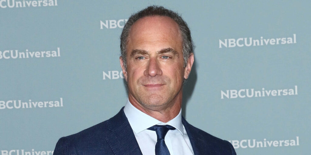 Christopher Meloni in blue suit and tie posing confidently at NBCUniversal backdrop portrait Wallpaper