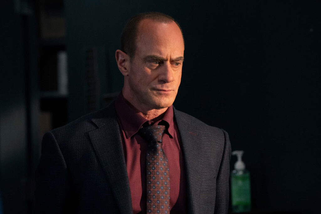 Christopher Meloni intense portrait dark suit maroon shirt patterned tie dramatic lighting wallpaper