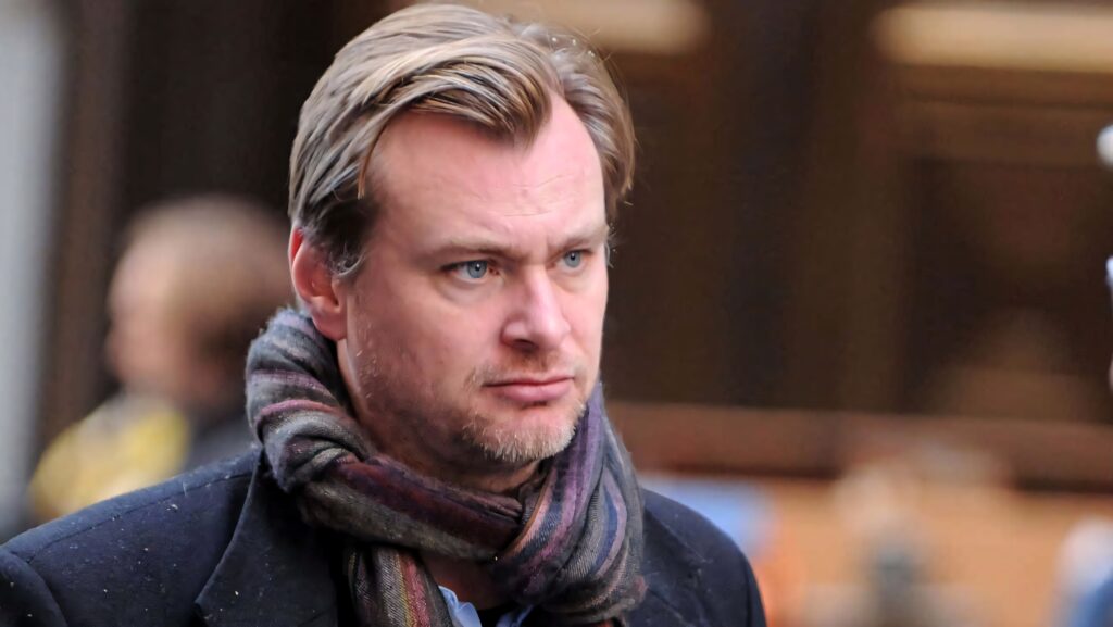 Christopher Nolan candid portrait with focused expression and stylish scarf cinematic filmmaker wallpaper