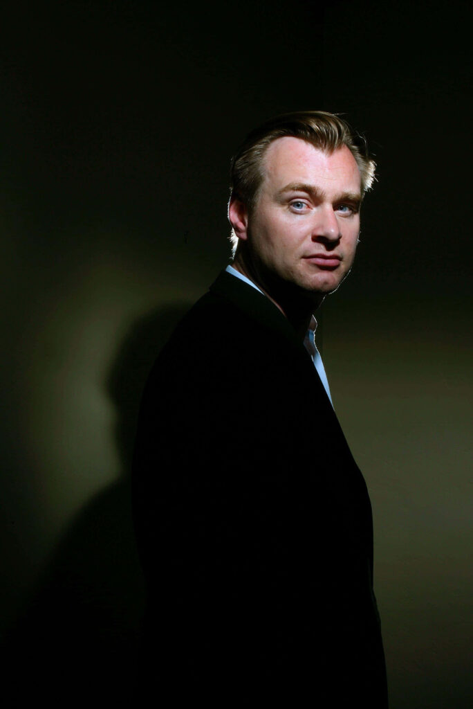 Christopher Nolan dramatic portrait with focused lighting sharp features dark minimalist background Wallpaper
