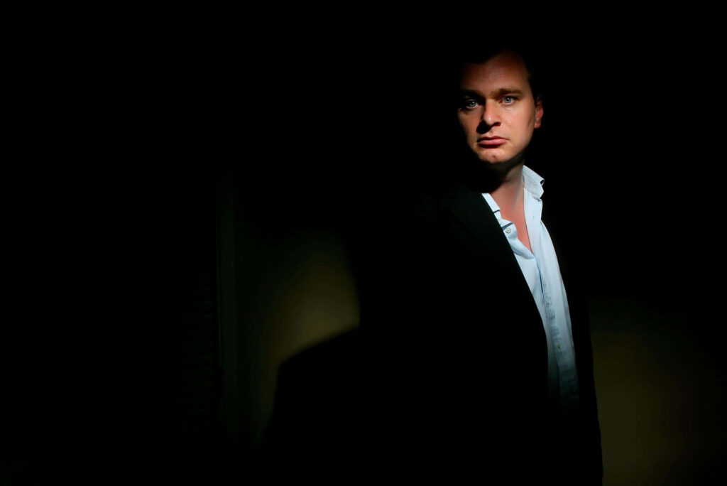 Christopher Nolan portrait wallpaper with dramatic lighting and cinematic shadowed background
