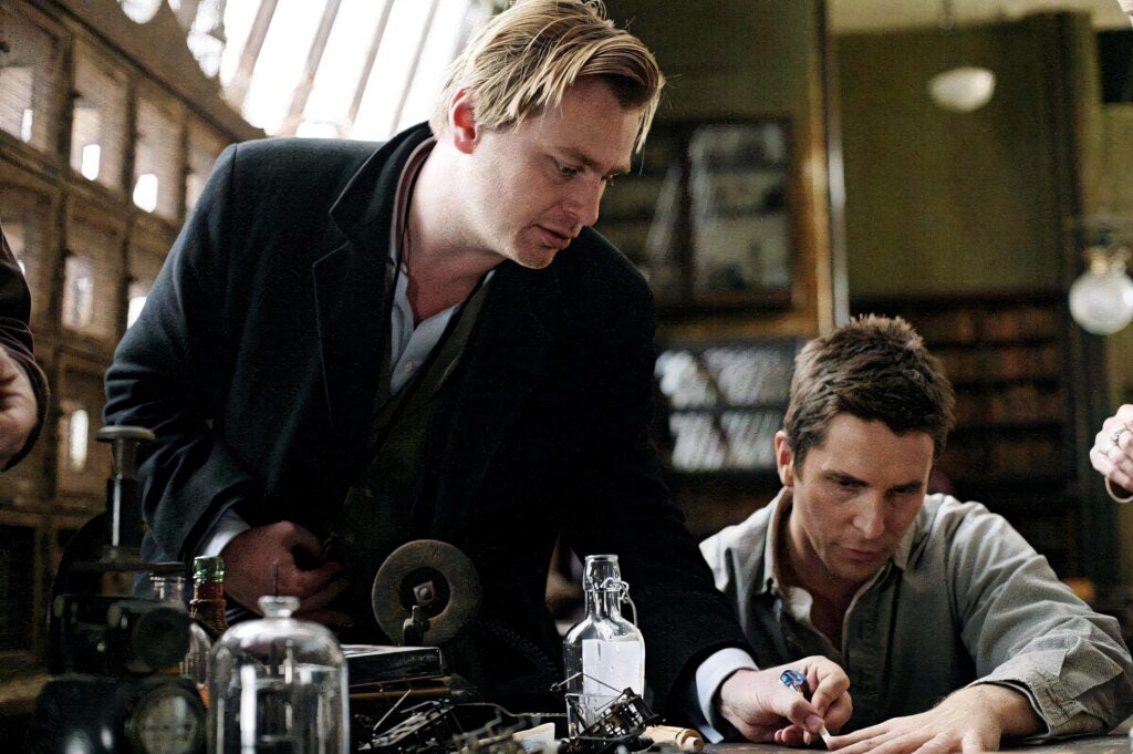 Christopher Nolan on set creative moment warm tones cluttered workspace visionary director wallpaper