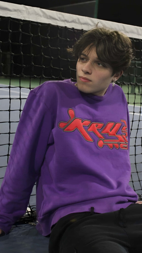 Christopher Sturniolo in purple sweatshirt by tennis net modern street style youthful energy wallpaper