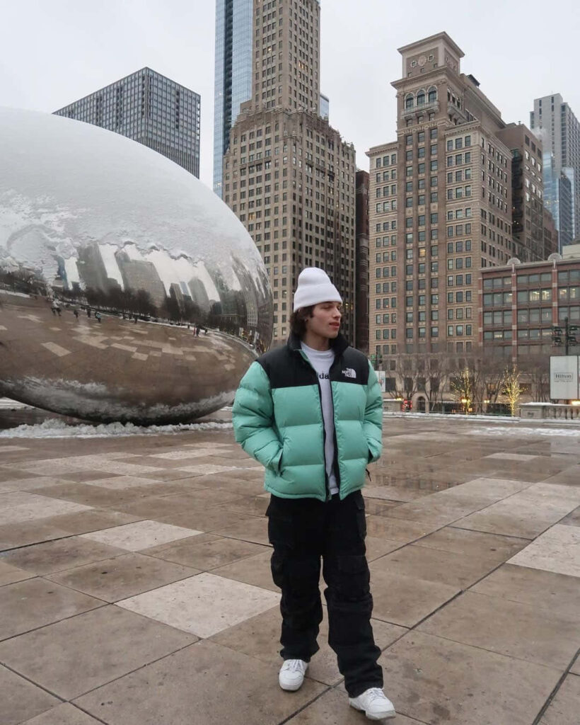 Christopher Sturniolo in mint green jacket by Chicago Cloud Gate with city skyscrapers winter style Wallpaper