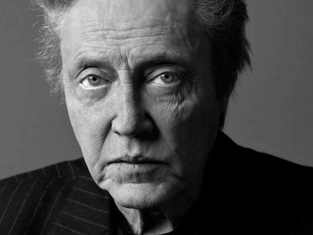 Greyscale wallpaper of Christopher Walken intense face deep-set eyes textured skin dramatic lighting