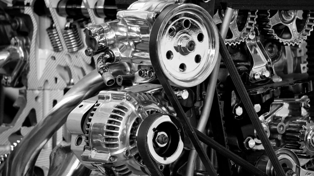 Close-up monochrome chrome automotive engine with polished pulleys and drive belts wallpaper