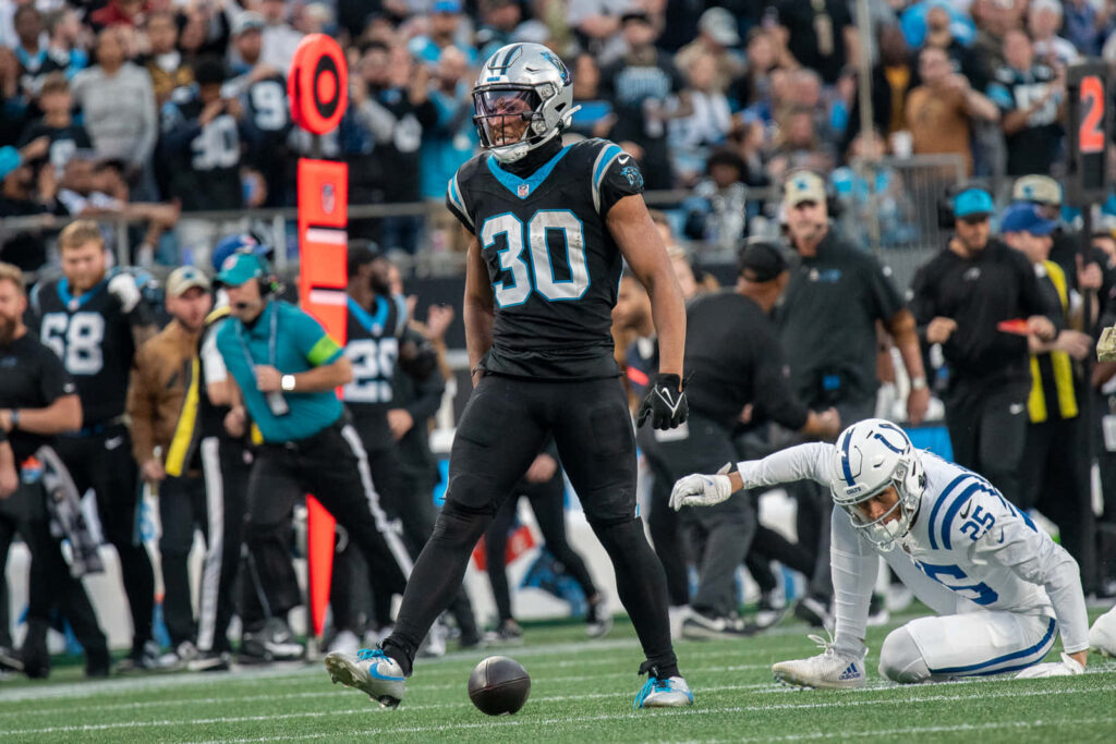 Football player Chuba Hubbard in Carolina Panthers uniform running on field action wallpaper background
