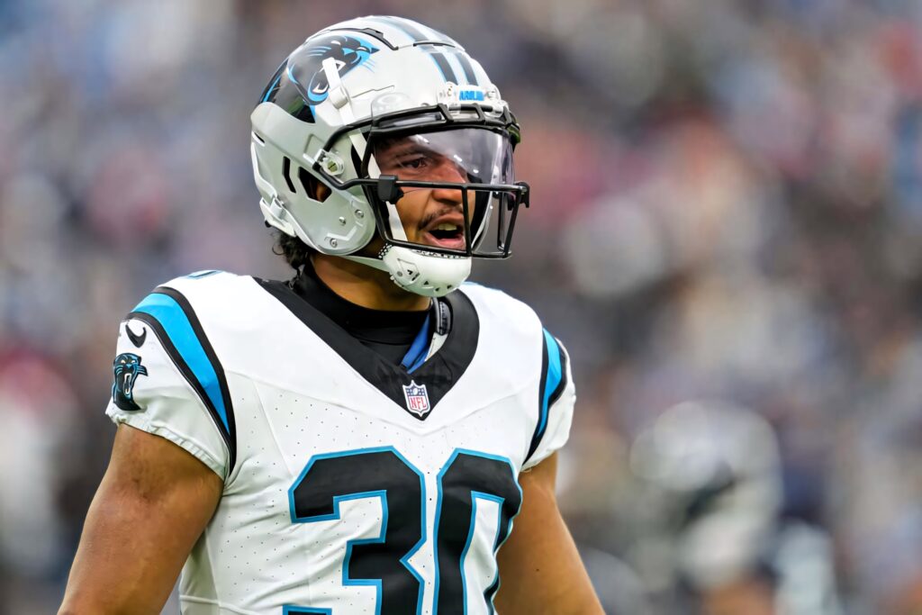Football player Chuba Hubbard in Carolina Panthers uniform sprinting with focus in NFL game wallpaper