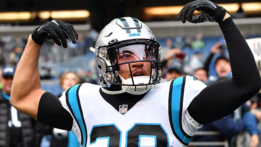 Carolina Panthers running back Chuba Hubbard flexes muscles celebrating in vibrant stadium wallpaper