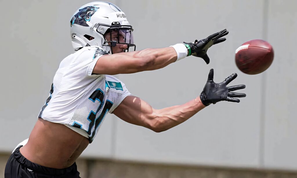 Chuba Hubbard catches football in Carolina Panthers uniform showing focus and intense motion Wallpaper