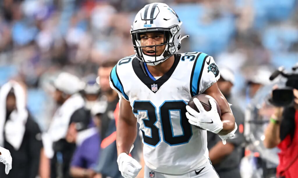 Chuba Hubbard Carolina Panthers running back powering forward with football in white blue uniform Wallpaper