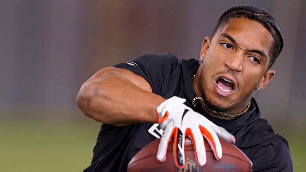 Chuba Hubbard focused catching football dynamic athletic build action energy blurred background Wallpaper