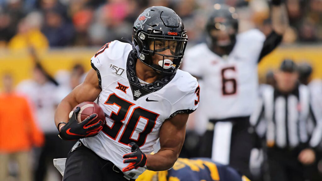 Chuba Hubbard Oklahoma State running back sprinting fast in vibrant action football wallpaper background