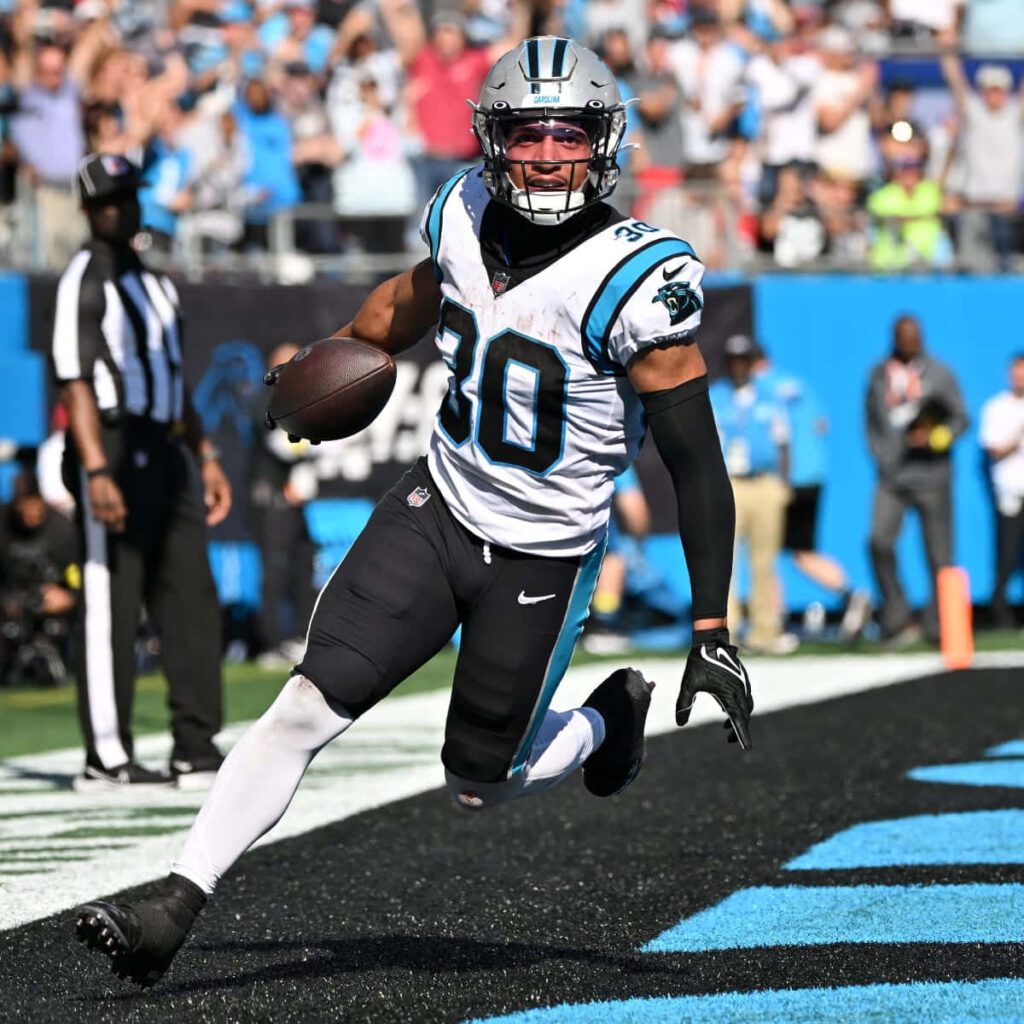 Chuba Hubbard touchdown celebration in Carolina Panthers colors with energetic stadium crowd background Wallpaper