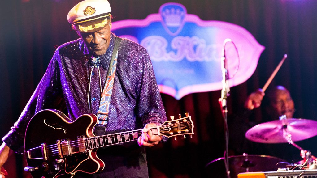 Chuck Berry performing live with electric guitar in purple lighting at B.B. King’s Blues Club wallpaper
