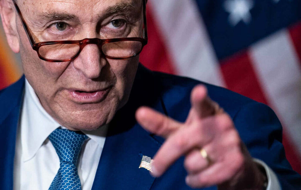 Close-up of Senator Chuck Schumer with American flag background in sharp patriotic photojournalistic style Wallpaper