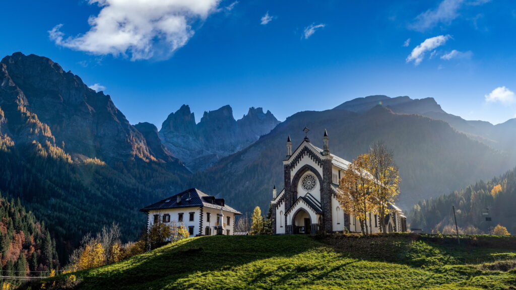 Majestic Mountain Churches: A Serene Alpine Retreat Amongst Nature's Cradle Wallpaper