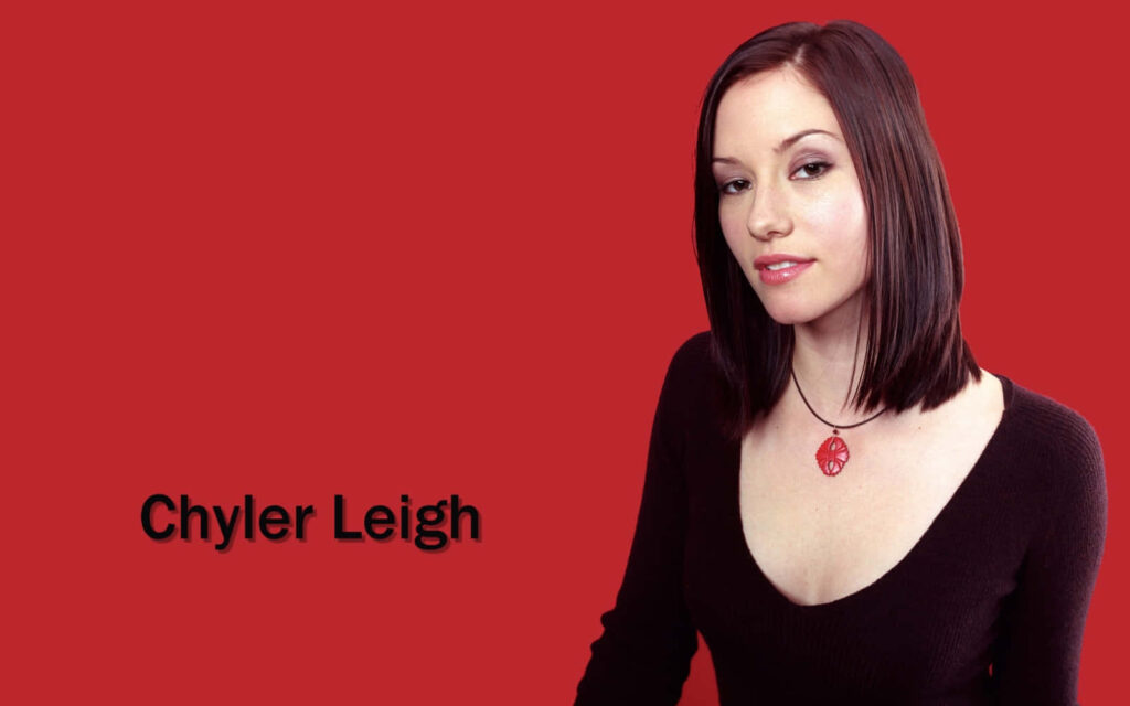 Chyler Leigh confident portrait with dark hair red background deep V-neck top modern wallpaper