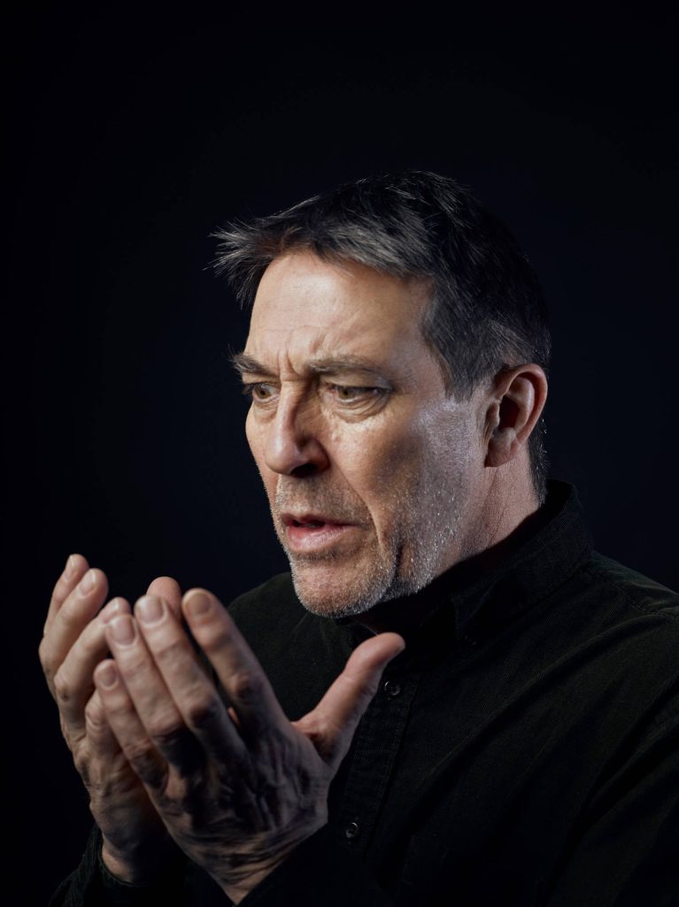 Studio portrait of Irish actor Ciarán Hinds with moody lighting and contemplative expression Wallpaper