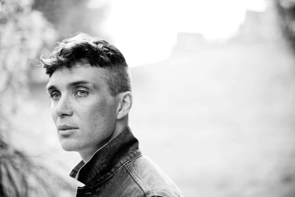 Black and white wallpaper of Cillian Murphy with sharp features gazing thoughtfully background