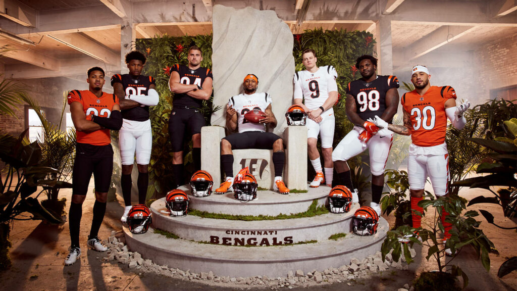 Cincinnati Bengals players showcasing 2021 bold black white orange tiger stripe uniforms on modern indoor background Wallpaper