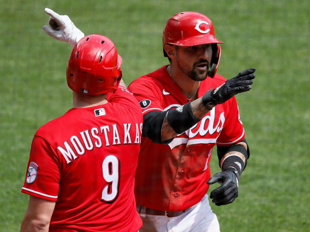 Cincinnati Reds players celebrating 2021 season start in vibrant red uniforms stadium sunlight Wallpaper