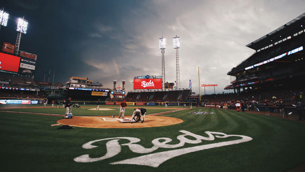 Cincinnati Reds ballpark at dusk with dramatic clouds illuminated stadium and vibrant green turf Wallpaper