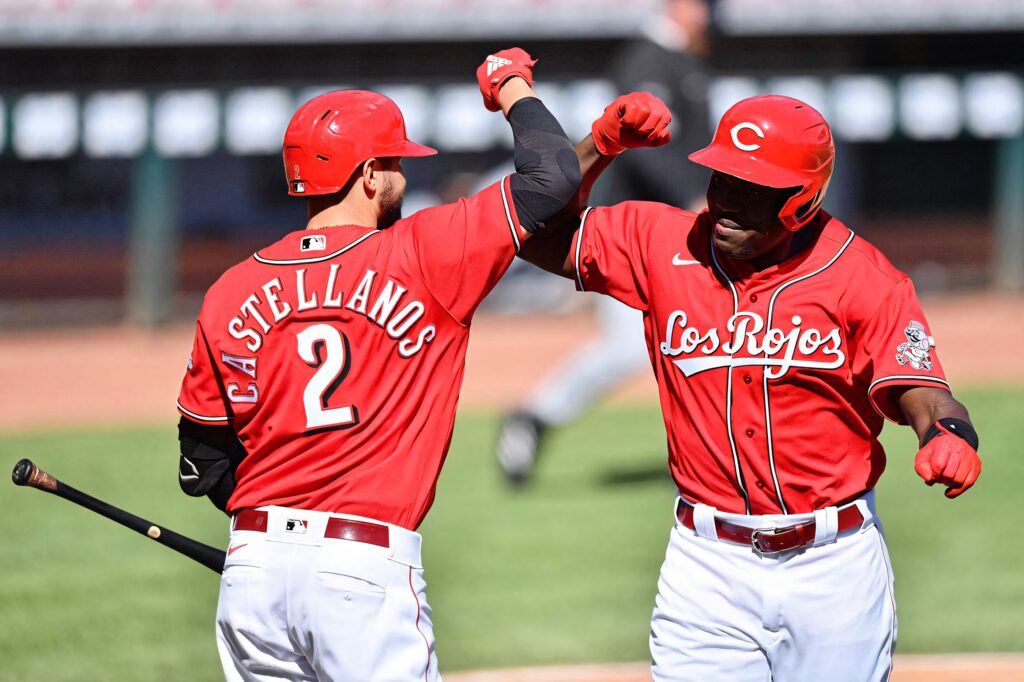 Cincinnati Reds players in red uniforms celebrating with bold Los Rojos and Castellanos details Wallpaper