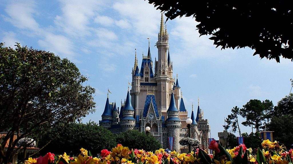 Cinderella Castle at Walt Disney World Magic Kingdom with vibrant flowers and sunny sky wallpaper