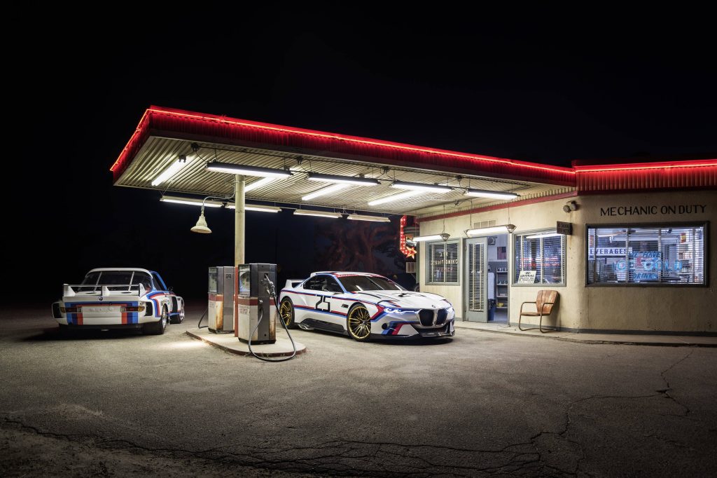 Classic BMW 3.0 CSL and futuristic Hommage R concept car lit at night gas station wallpaper background