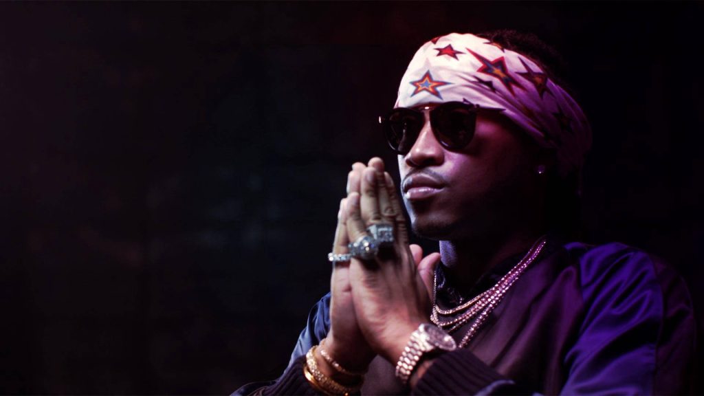 Rapper Future in dark moody setting praying with star headband sunglasses diamond chains wallpaper