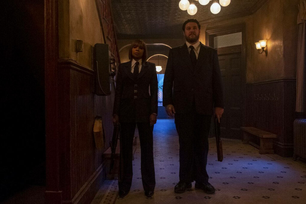Cinematic Wallpaper: Assassins Hazel & Cha-Cha in Dimly Lit Hallway