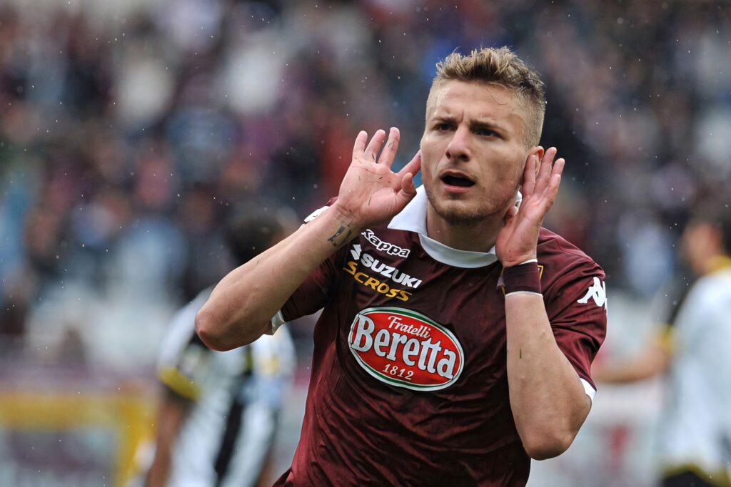 Ciro Immobile celebrating goal wearing Torino maroon kit intense expression stadium background Wallpaper