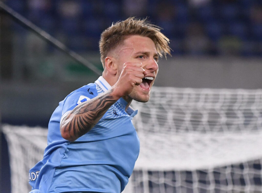 Ciro Immobile celebrating passionately in Lazio kit with intense expression and tattooed arm Wallpaper