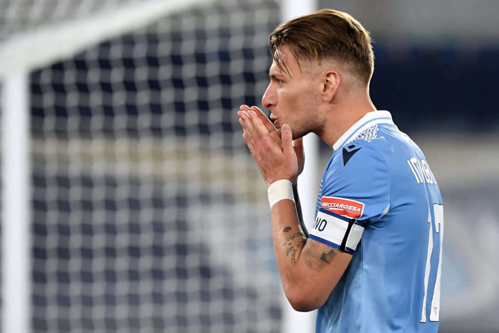 Ciro Immobile Lazio footballer focused intense in blue kit blurred stadium background wallpaper