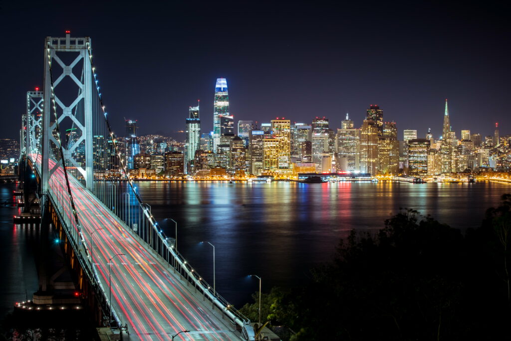 San Francisco Nightscapes: Illuminated Bay Bridge merging the City's Skyline and Architectural Splendor in stunning HD Wallpaper