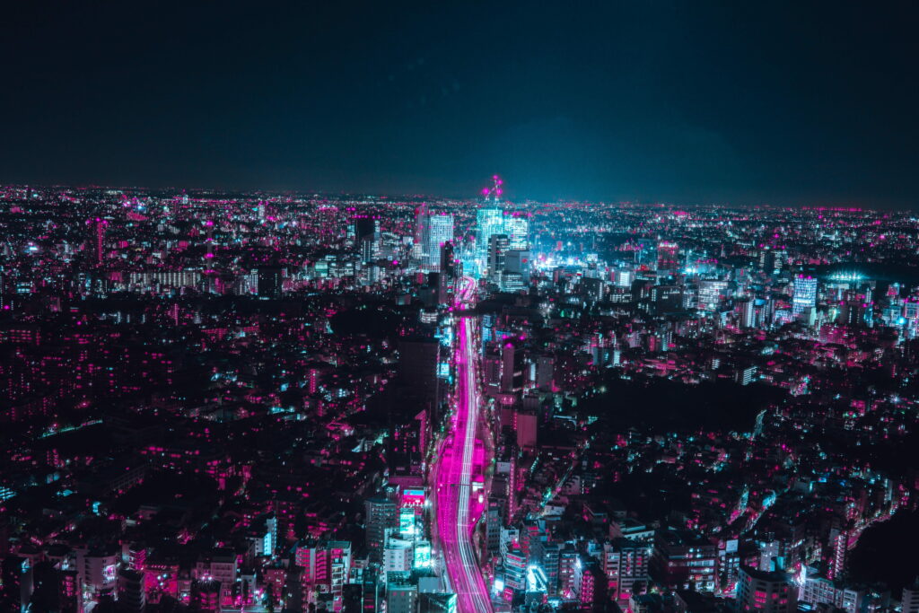High-angle cyberpunk cityscape with neon purple cyan lights and vibrant night street trails Wallpaper
