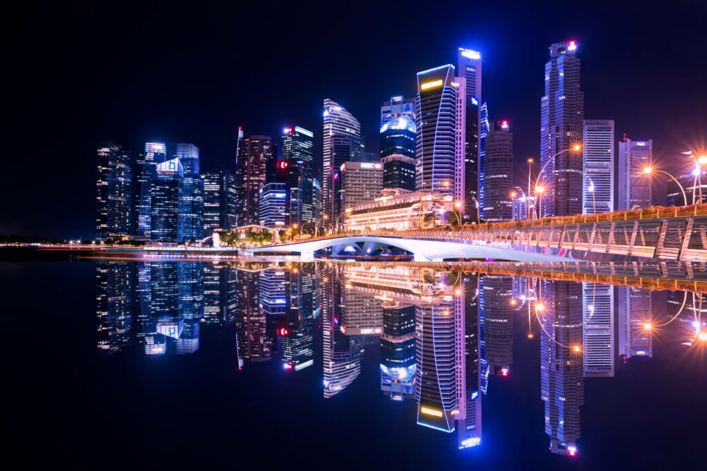 Captivating Nighttime Cityscape Glistens with Mesmerizing Neon Illuminations Reflected in the Shimmering Water Wallpaper
