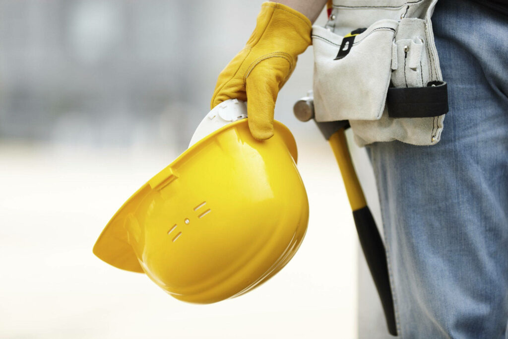 Close-up of civil engineer holding yellow safety helmet with gloves and tool belt construction Wallpaper