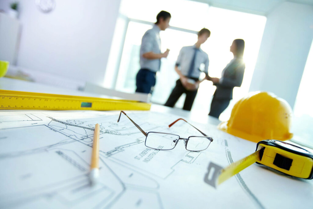 Civil engineering blueprints tools safety helmet teamwork professionals workspace background Wallpaper