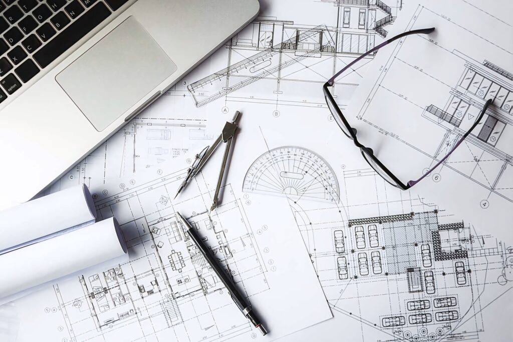 Civil engineering blueprints with drafting tools laptop and eyeglasses on monochrome workspace background Wallpaper