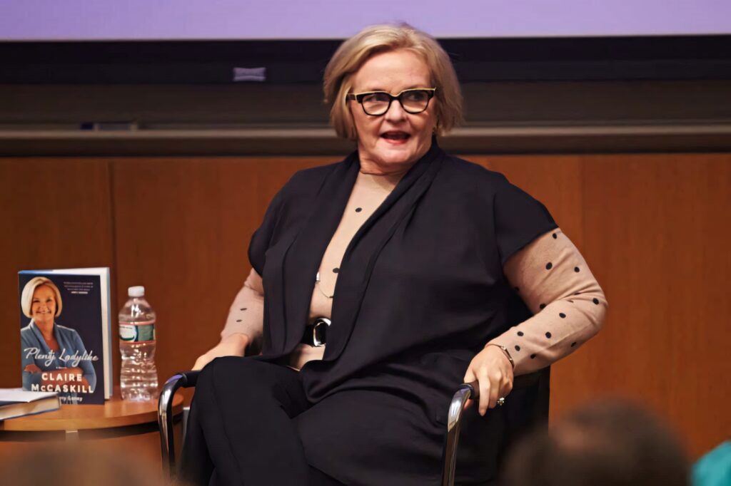 Claire McCaskill speaking at book tour with Plenty Ladylike beside her in warm modern setting Wallpaper
