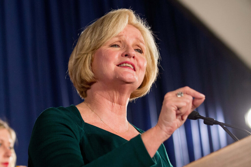 Claire McCaskill confident portrait speaking at podium deep blue curtain professional candid photo Wallpaper