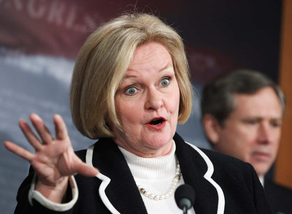 Claire McCaskill delivers passionate speech with expressive gestures in formal setting wallpaper background