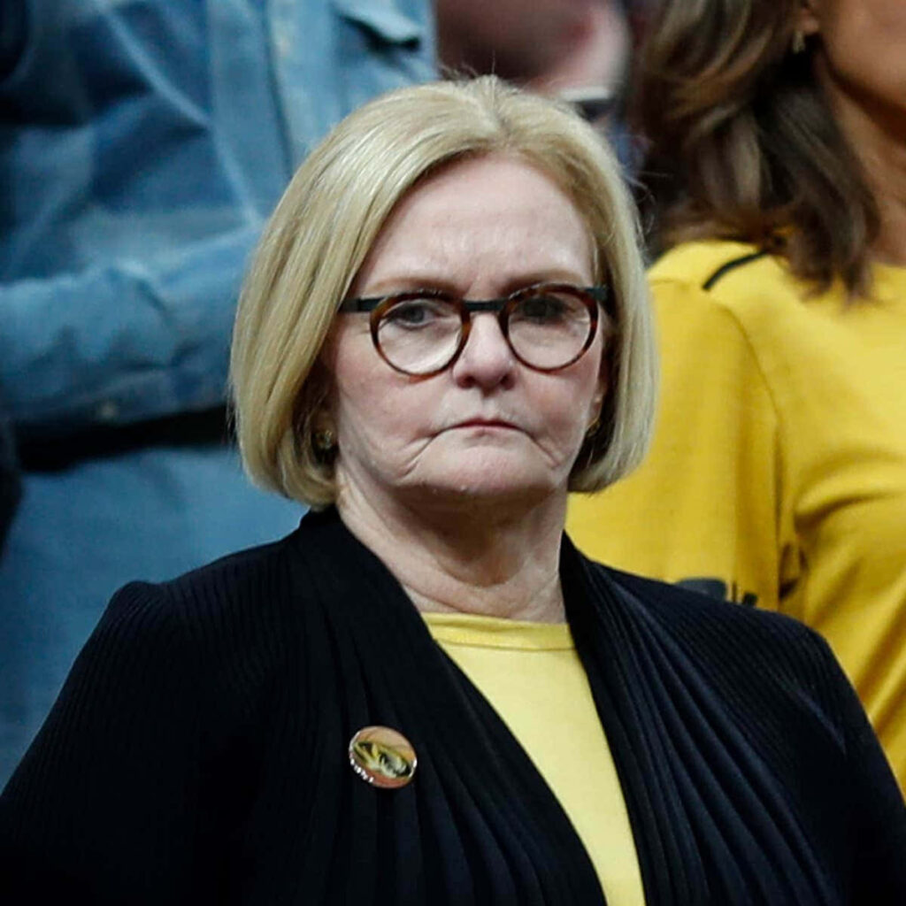 Claire McCaskill serious contemplative expression yellow top black jacket round glasses wallpaper