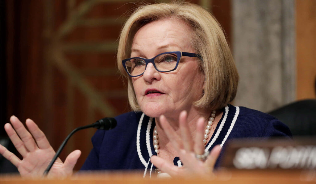Claire McCaskill speaking in Senate chamber during hearing wearing navy blazer and pearls Wallpaper