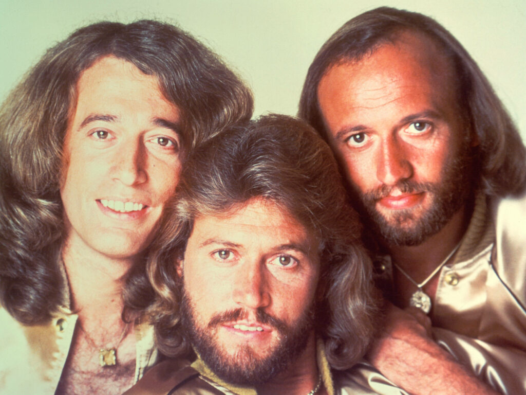1977 Bee Gees portrait wallpaper featuring Barry Robin and Maurice Gibb in coordinated outfits