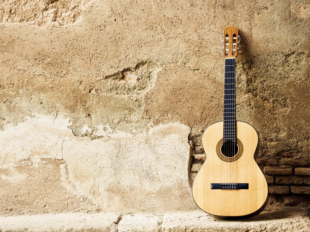 Timeless Acoustic Guitar Against Rustic Wall - Wallpaper Background